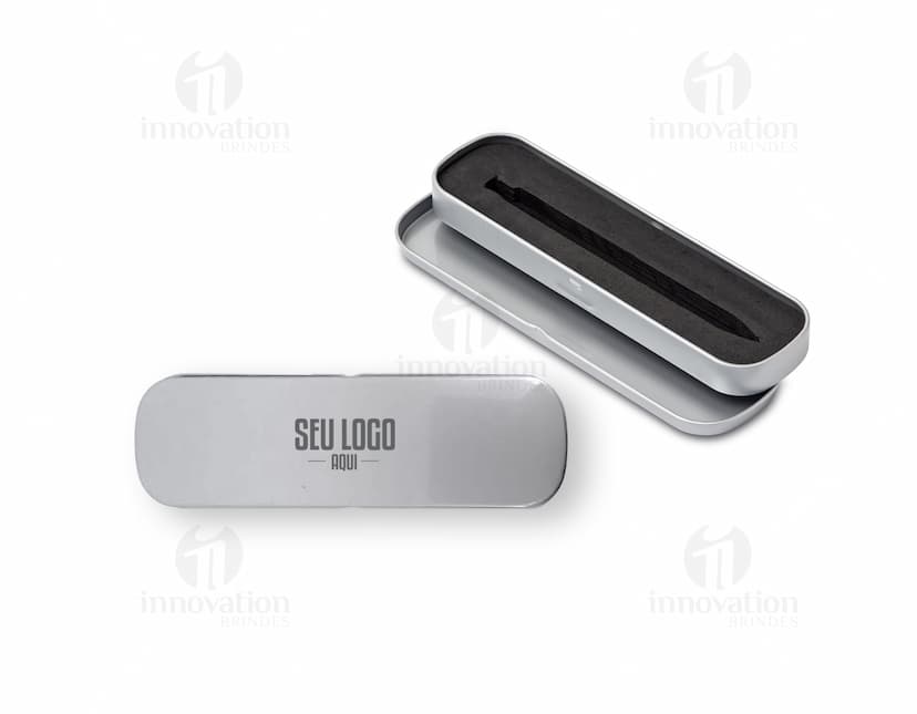Estojo de metal preto vazio, com design moderno e prateado. Na imagem, há também uma caneta, uma chave de computador, um modem, um pen drive e um ferro de passar. O estojo contém ainda um grampeador, um modem, um drive de armazenamento e um botão preto.