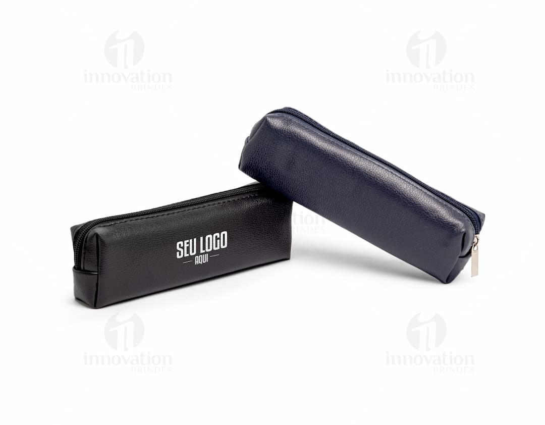 Estojo de couro sintético preto fechado contendo dinheiro, cartão, caneta, e outros itens de escritório.