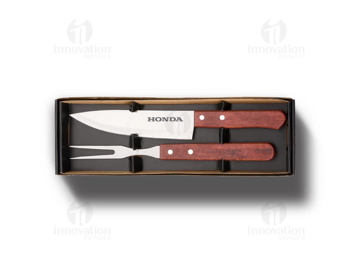 Um conjunto de dois utensílios de churrasco em aço inoxidável, incluindo faca e garfo. Os utensílios são de cor prata, com design clássico e acabamento brilhante. Perfeitos para uso em churrascos, com cabo de madeira para maior conforto durante o manuseio.