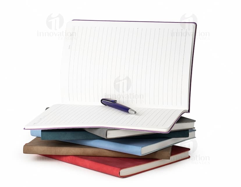 Caderno B5 PU preto sobre uma mesa de escritório, ao lado de um laptop, teclado, mouse e disco de vídeo. A imagem também mostra um disco óptico, botões, tela de monitor, tecla e conectividade wireless.