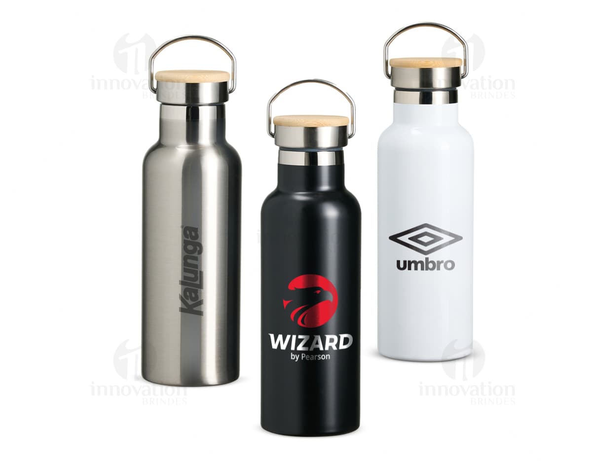 Garrafa térmica inox de 500ml com rótulo marrom e tampa, contendo líquido transparente. A garrafa está sobre um fundo branco refletindo a luz, indicando frescor e higiene.
