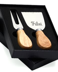 Kit Queijo 2 Peças em madeira de cor preta e marrom. Inclui uma ferramenta de moldar queijo e um carimbo para selar. Retrata um objeto de design artesanal ideal para menu de café da manhã, almoço e jantar.