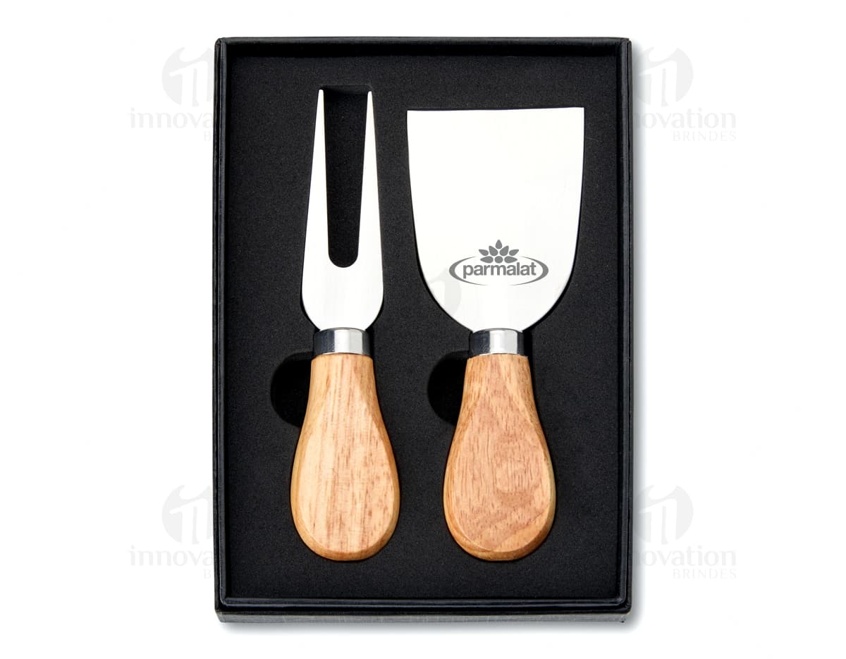 Kit Queijo 2 Peças em madeira de cor preta e marrom. Inclui uma ferramenta de moldar queijo e um carimbo para selar. Retrata um objeto de design artesanal ideal para menu de café da manhã, almoço e jantar.