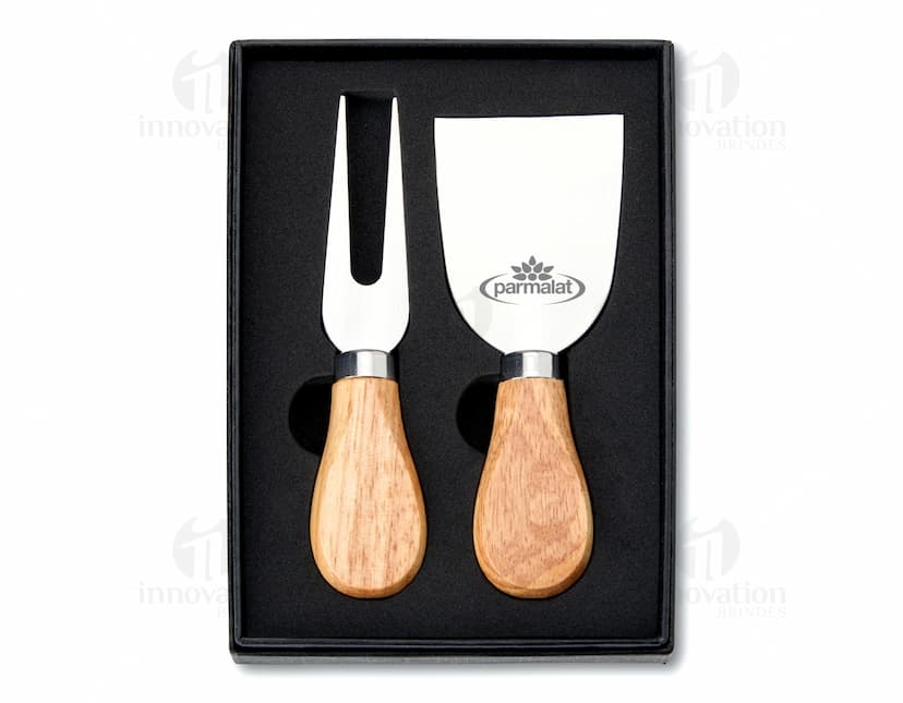 Kit Queijo 2 Peças em madeira de cor preta e marrom. Inclui uma ferramenta de moldar queijo e um carimbo para selar. Retrata um objeto de design artesanal ideal para menu de café da manhã, almoço e jantar.