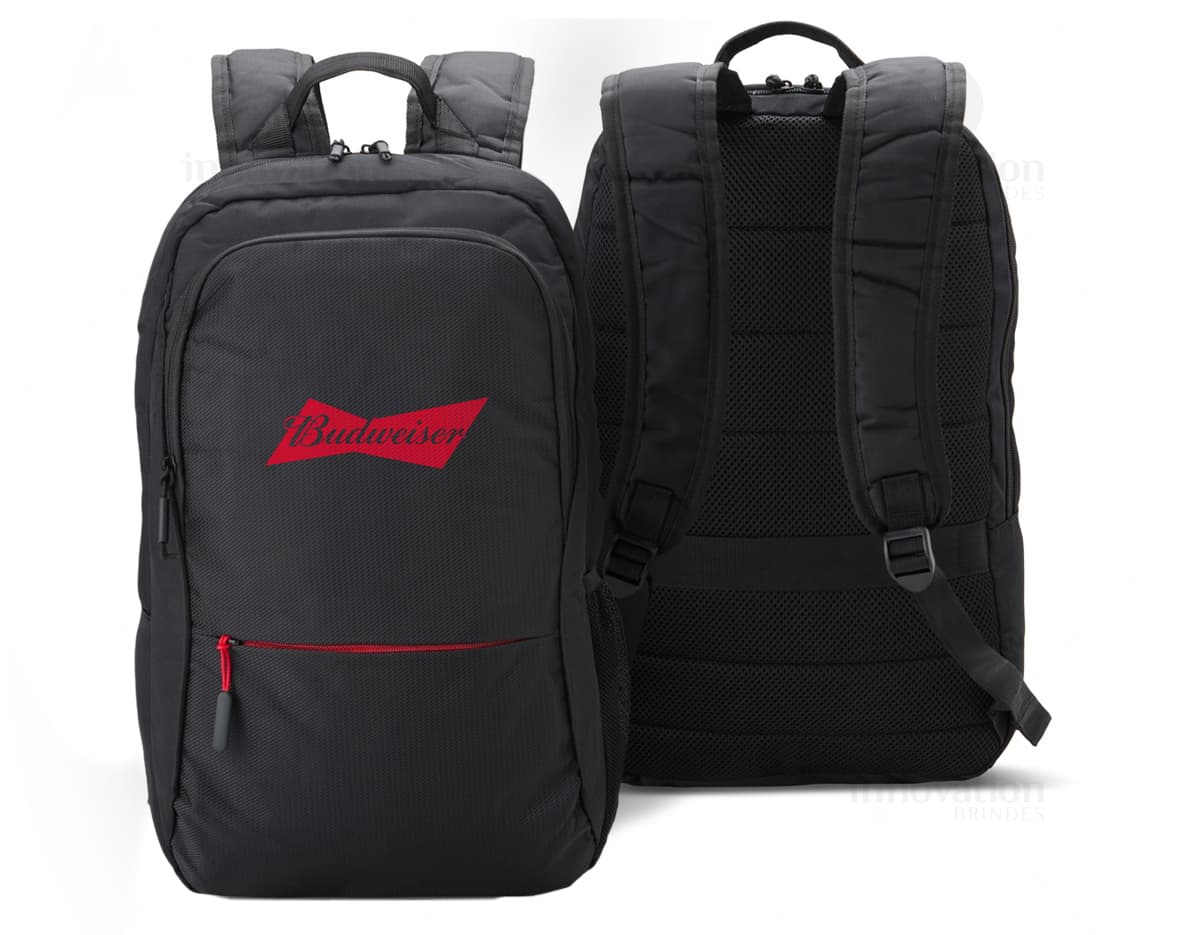 Homem de negócios sorridente e bem-sucedido em um terno preto, segurando uma mochila de nylon de 25L. O homem está em pé, olhando confiante e feliz, em um ambiente de escritório moderno.