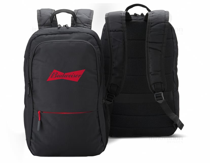 Homem de negócios sorridente e bem-sucedido em um terno preto, segurando uma mochila de nylon de 25L. O homem está em pé, olhando confiante e feliz, em um ambiente de escritório moderno.