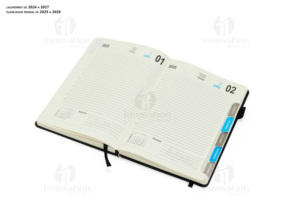 Agenda Diária 2025 em couro marrom, aberta sobre um notebook preto com papel em branco, teclado de computador e diversos objetos de escritório ao redor, como caneta, carteira, pasta e dinheiro.