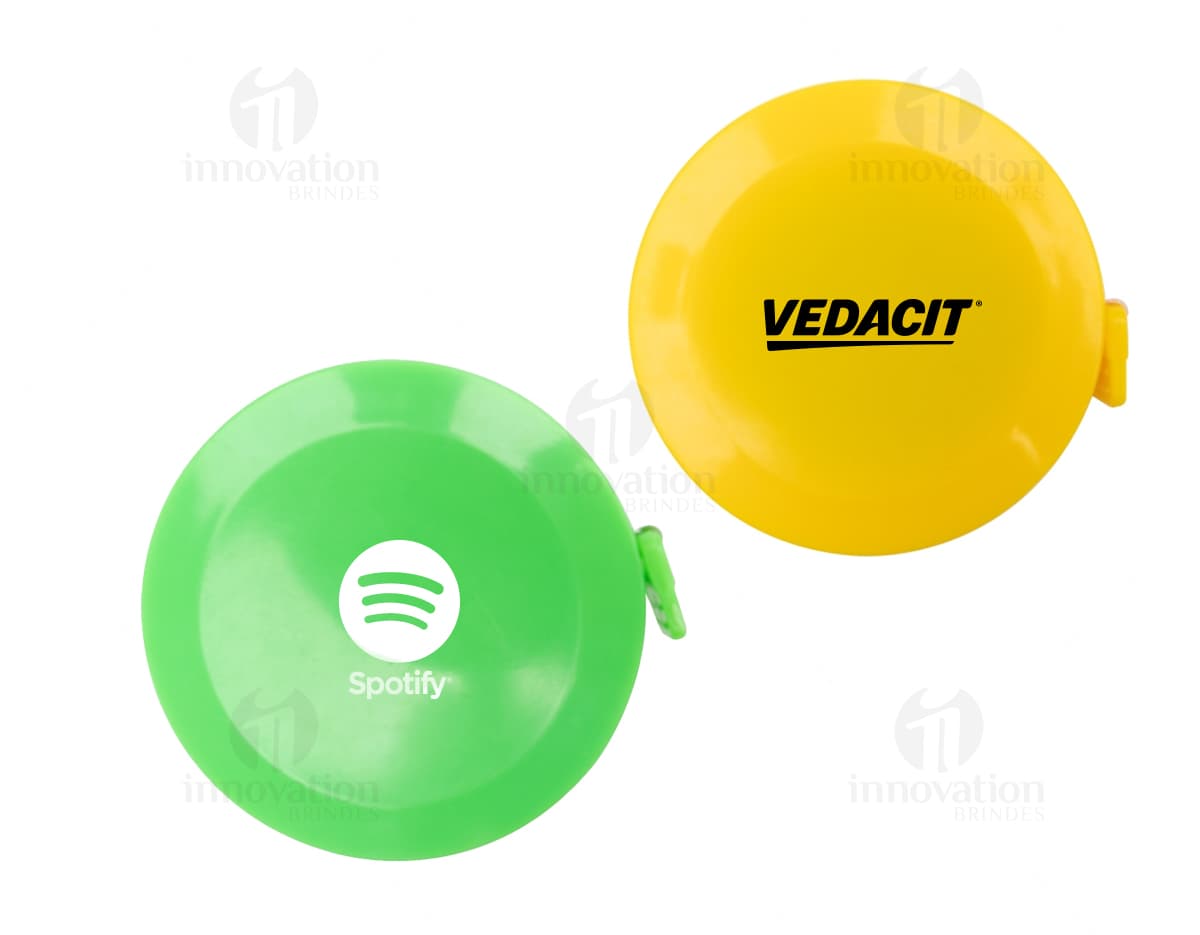 Botão circular de plástico laranja com ícone de fita métrica. A imagem mostra um botão brilhante com símbolo de medição, design 3D, luz reflexiva e sombra, representando um equipamento de jogo.