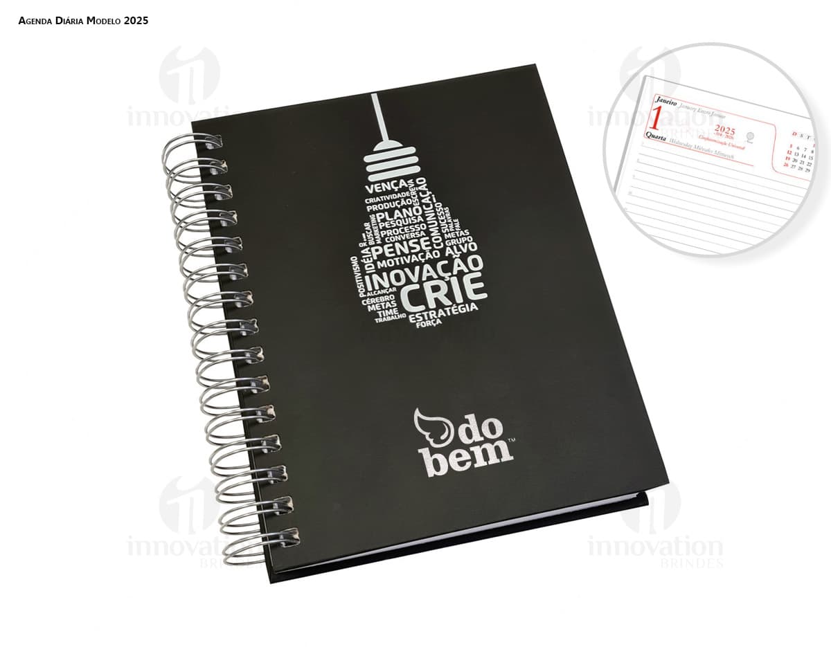 Agenda Wire-o em formato de espiral com capa preta e páginas em branco aberta em cima de uma mesa de escritório.