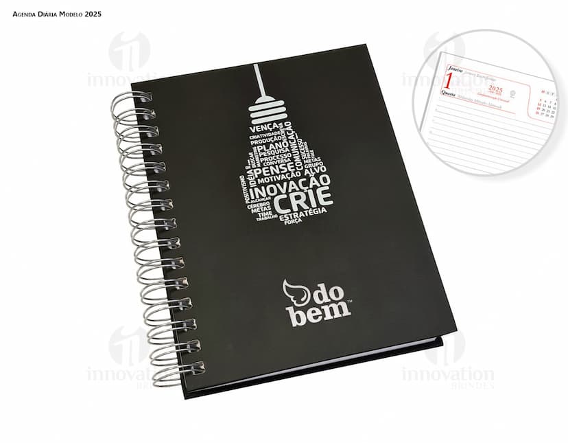 Agenda Wire-o em formato de espiral com capa preta e páginas em branco aberta em cima de uma mesa de escritório.