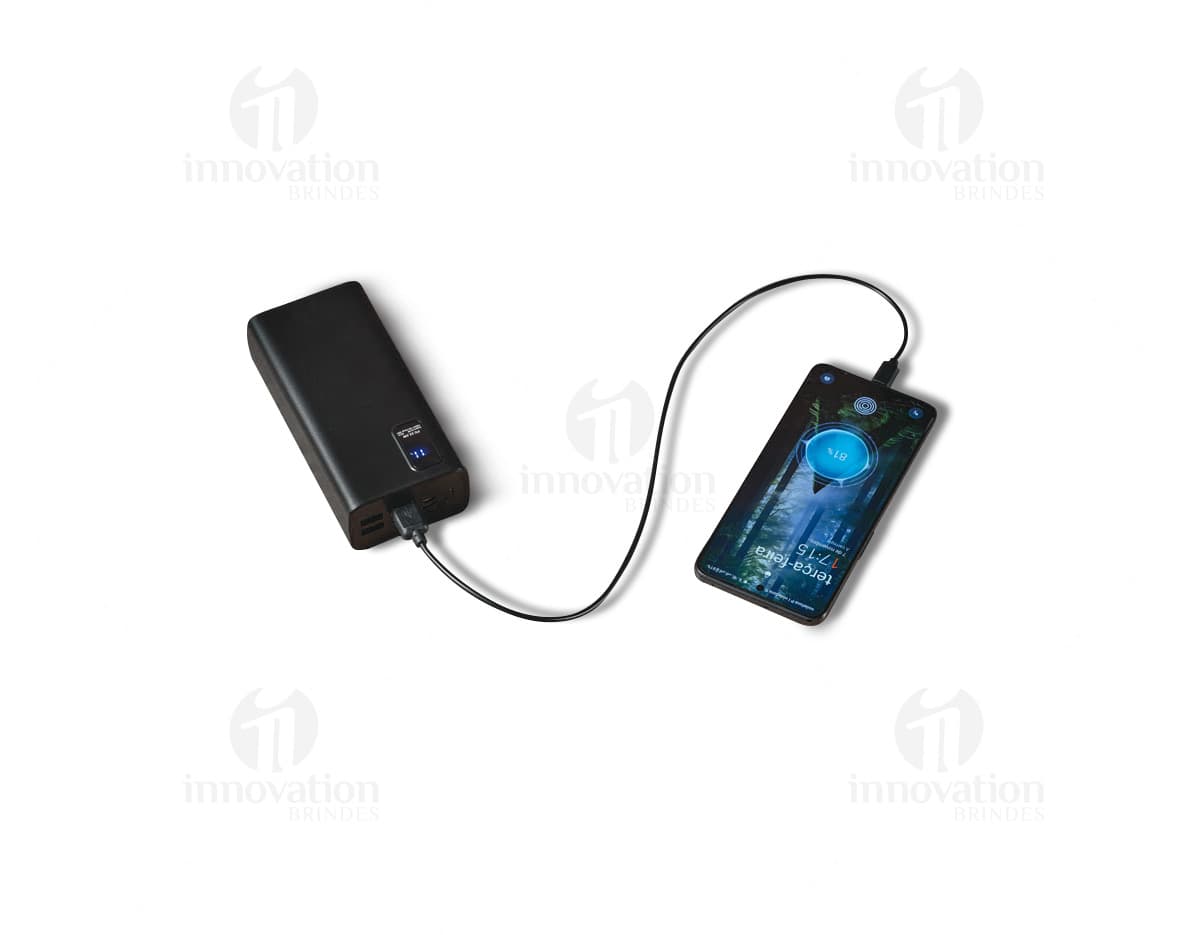 Equipamento moderno de tecnologia, uma bateria portátil em lítio com capacidade de 30.000 mAh, em um design preto e prata. Ideal para armazenamento e fornecimento de energia para dispositivos eletrônicos móveis, com conexão USB e botões de controle. Perfeito para uso em casa, escritório, estúdio ou em festas, garantindo entretenimento com alta qualidade de som através de seu alto-falante estéreo embutido.
