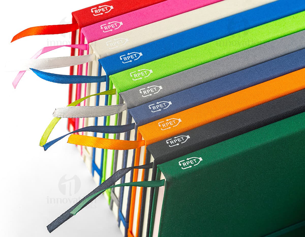 Caderno A5 de capa dura azul com elástico e marcador de páginas.