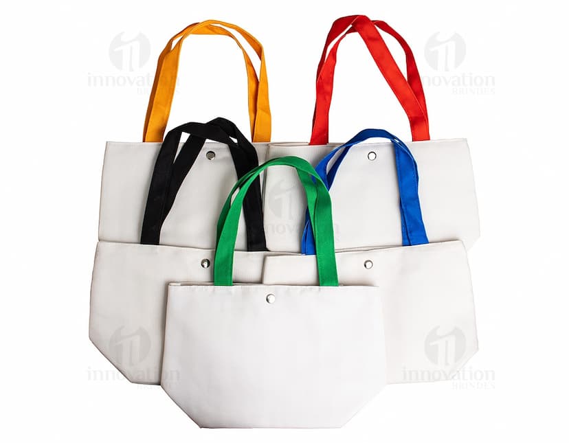 Bolsa de lona na cor azul-marinho com alças de couro marrom e fecho de zíper na parte superior.