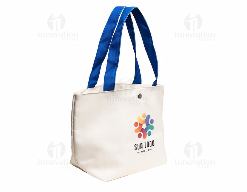 Bolsa de lona na cor azul-marinho com alças de couro marrom e fecho de zíper na parte superior.