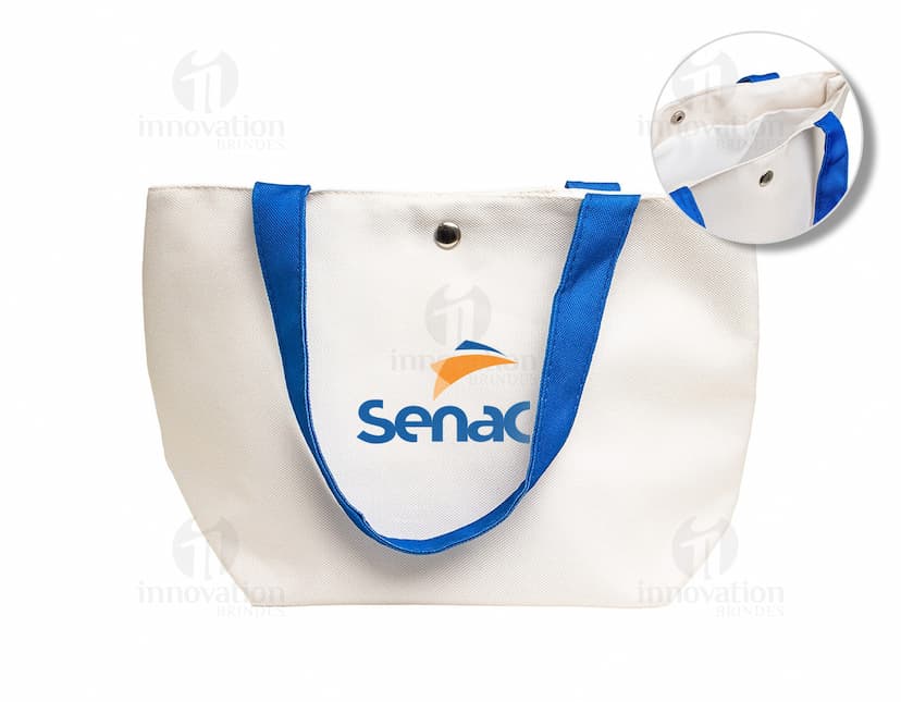 Bolsa de lona na cor azul-marinho com alças de couro marrom e fecho de zíper na parte superior.