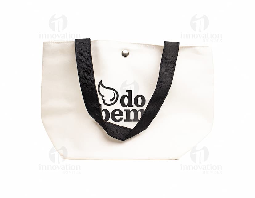 Bolsa de lona na cor azul-marinho com alças de couro marrom e fecho de zíper na parte superior.