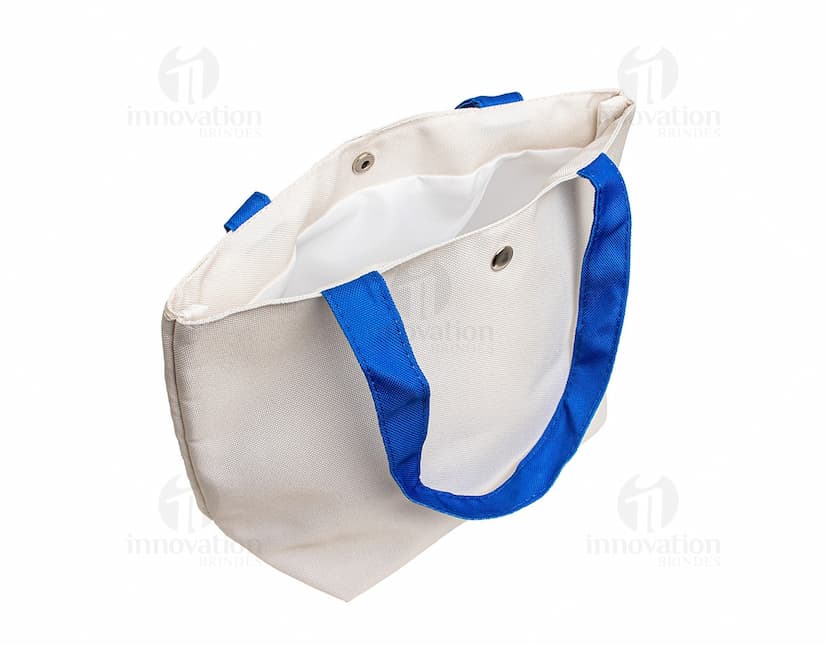 Bolsa de lona na cor azul-marinho com alças de couro marrom e fecho de zíper na parte superior.