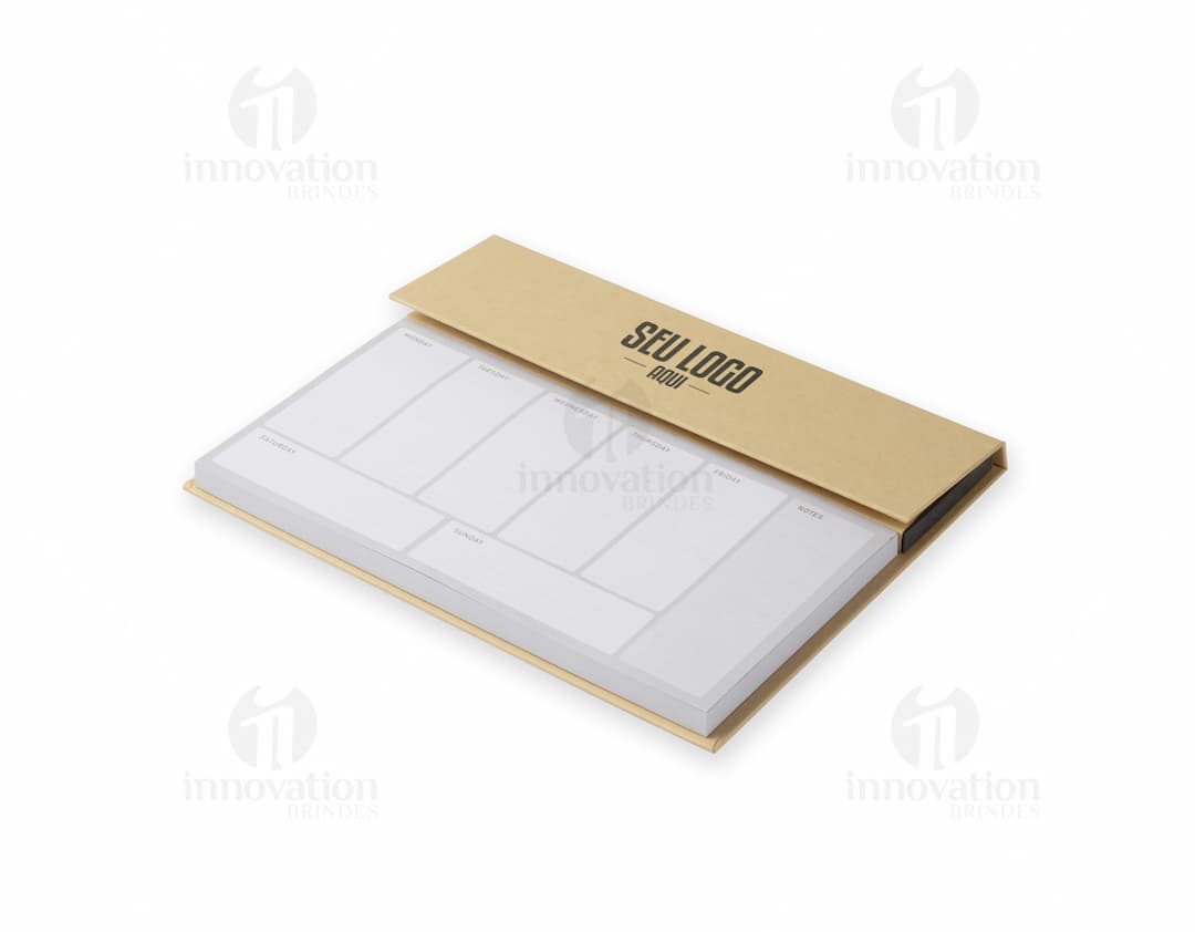 Bloco de anotações com planejamento aberto em uma mesa de escritório. No bloco, é possível ver páginas decoradas e datas planejadas. Além disso, há canetas e clips ao redor do bloco.