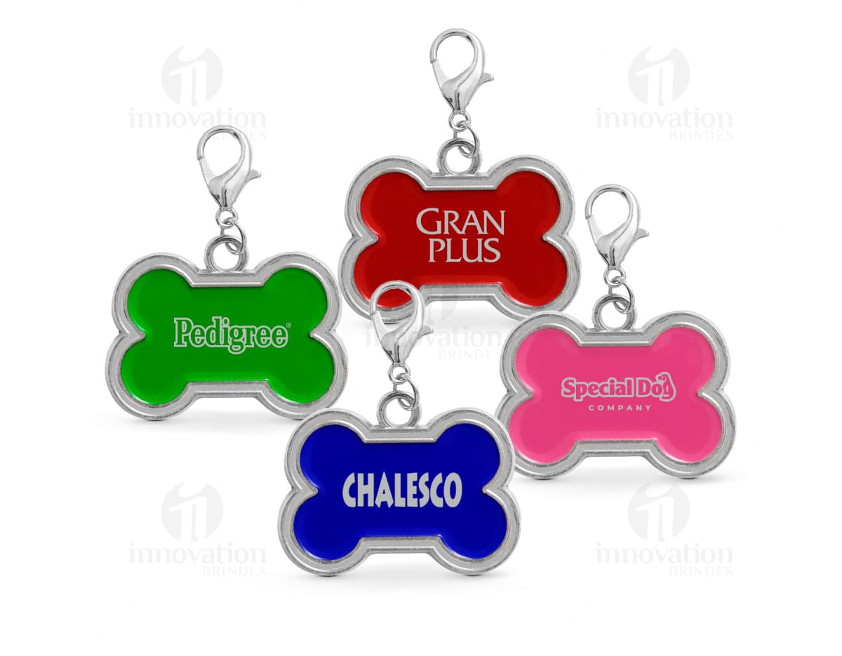 Chaveiro em formato de osso em cor prata com detalhes de patinhas.