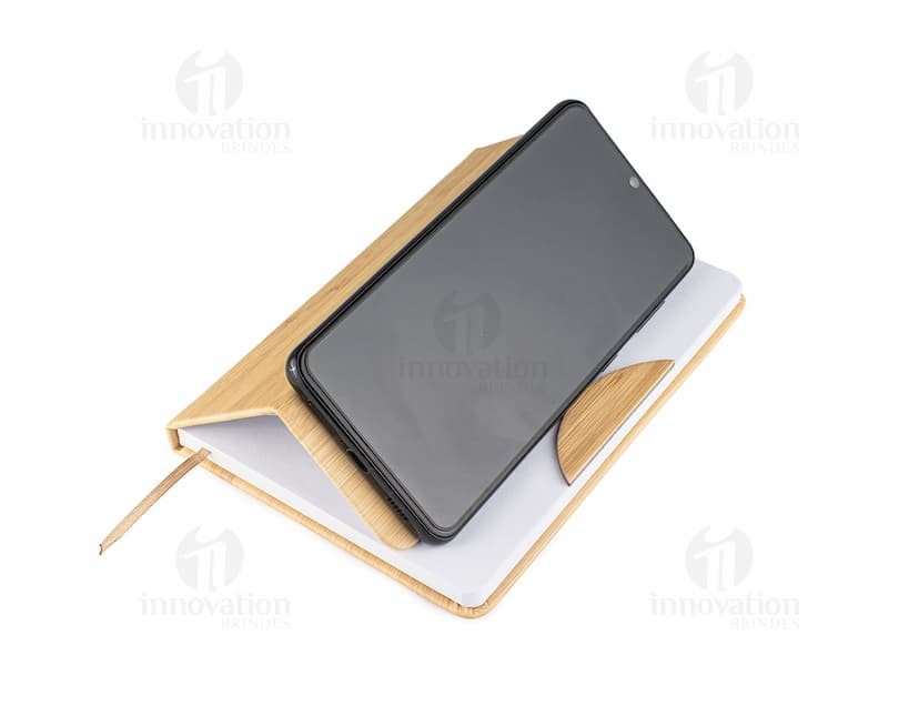 Caderneta com suporte para celular em cor rosa com elástico para prender o celular na capa frontal.