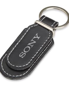 Chaveiro de Couro Sintético preto com argola de metal e detalhes costurados à mão.