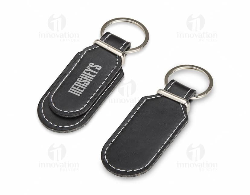 Chaveiro de Couro Sintético preto com argola de metal e detalhes costurados à mão.
