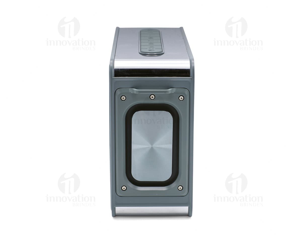Caixa de som 15.600 mAh de cor preta com design compacto e moderno. Na frente da caixa, há botões de controle de volume e luzes indicadoras de status da bateria.