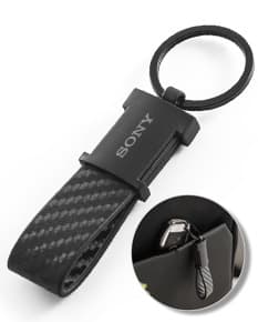 Chaveiro em couro sintético preto com detalhe de metal prateado em forma de coração.