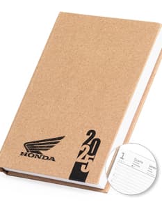 Agenda Diária 2025 com capa em couro marrom e gravura de uma árvore em dourado. Páginas internas brancas com datas e horários para organização do dia-a-dia.