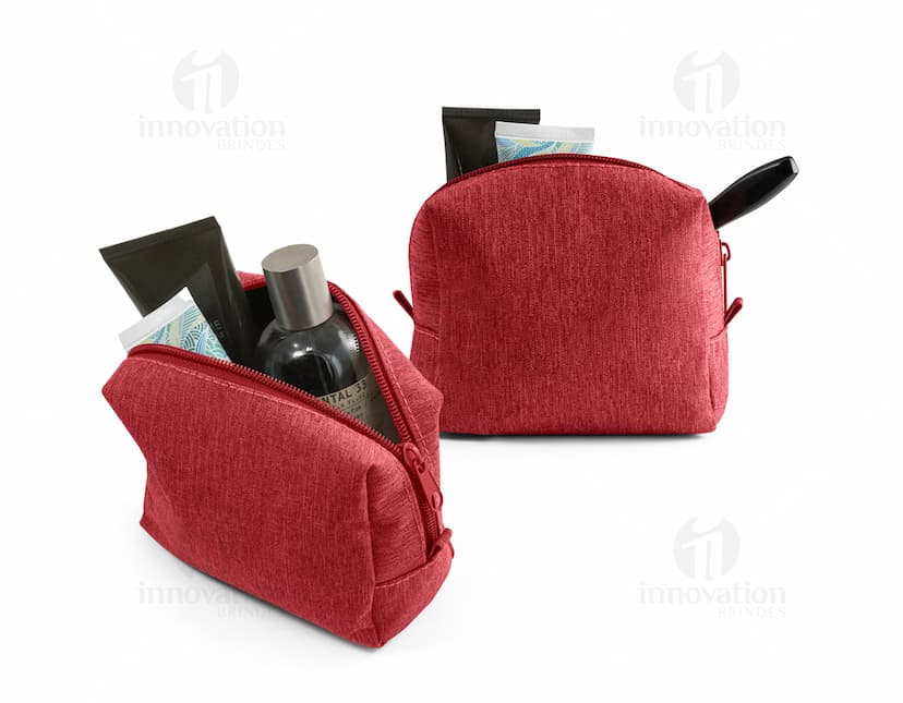 Bolsa para cosméticos preta com zíper e alça curta, contendo pincéis de maquiagem e batons organizados em seu interior.