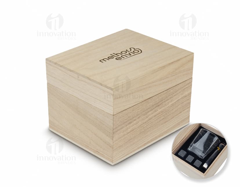 Kit Drink em uma caixa de papelão marrom. A embalagem está aberta e contém várias garrafas e copos empilhados. Ao redor da caixa, há diversos objetos de decoração e símbolos de riqueza, como um cofre, livros, um baú e uma impressora.