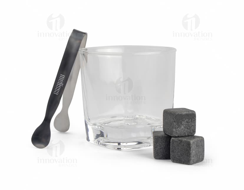 Kit Drink em uma caixa de papelão marrom. A embalagem está aberta e contém várias garrafas e copos empilhados. Ao redor da caixa, há diversos objetos de decoração e símbolos de riqueza, como um cofre, livros, um baú e uma impressora.