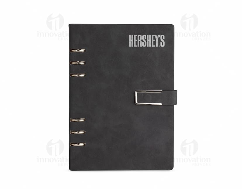 Caderno Fichário PU em cor preta, com fecho magnético e ferragem prateada.