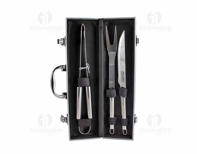 Kit Churrasco 3 Peças em aço inoxidável, contendo faca, garfo e pegador, sobre fundo branco.