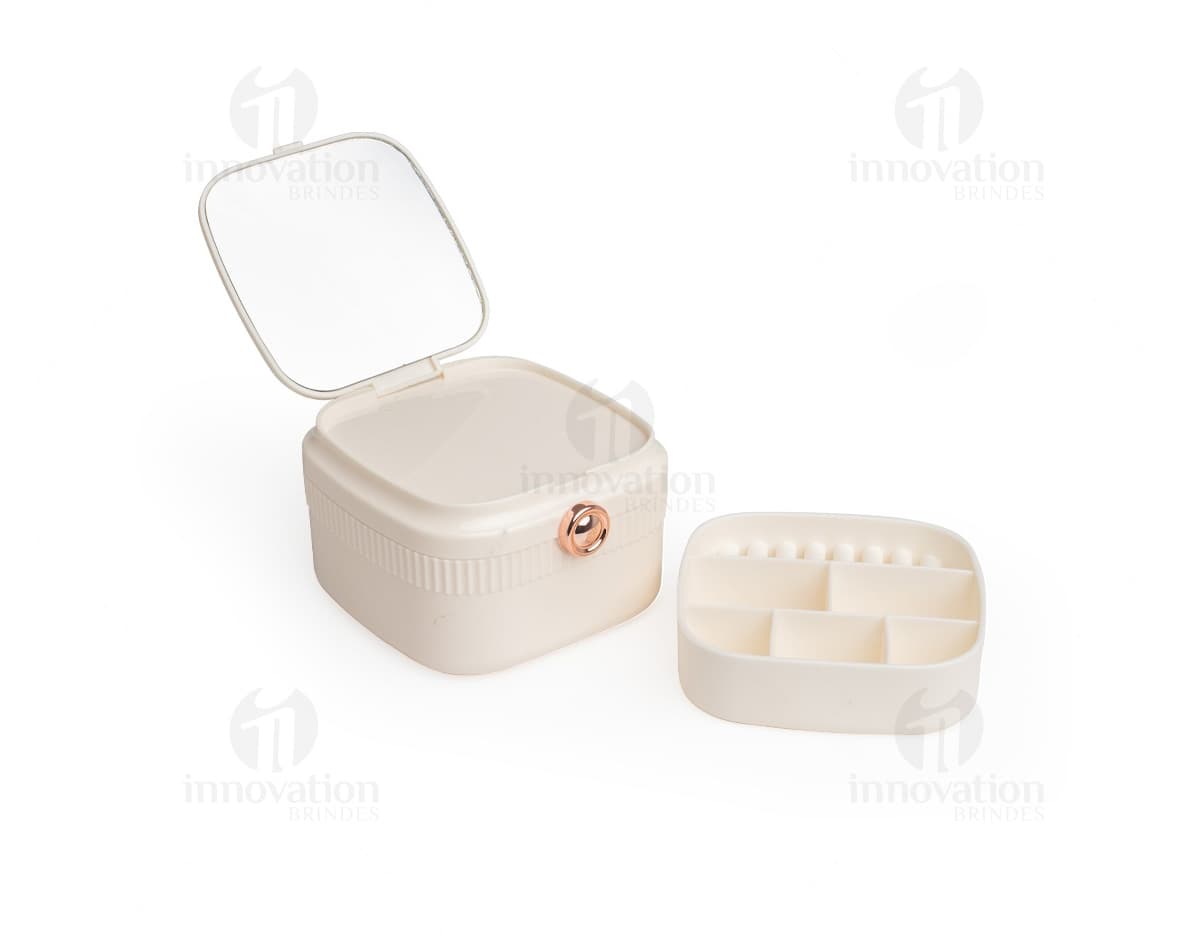 Porta-joias com espelho em formato retangular, com várias divisórias internas para organização de joias e acessórios. O exterior do porta-joias é revestido com um material brilhante e elegante. O espelho está localizado na parte interna da tampa do porta-joias.