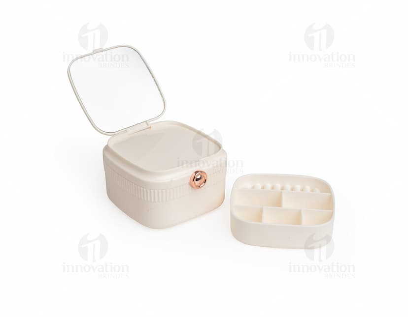 Porta-joias com espelho em formato retangular, com várias divisórias internas para organização de joias e acessórios. O exterior do porta-joias é revestido com um material brilhante e elegante. O espelho está localizado na parte interna da tampa do porta-joias.
