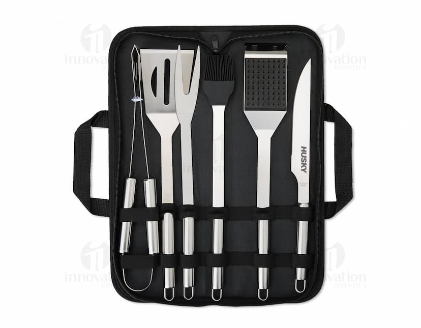Imagem de um Kit Churrasco 6 Peças, contendo ferramentas e utensílios para churrasco, como faca, garfo, espátula, pegador e escova, em uma maleta de couro preta.