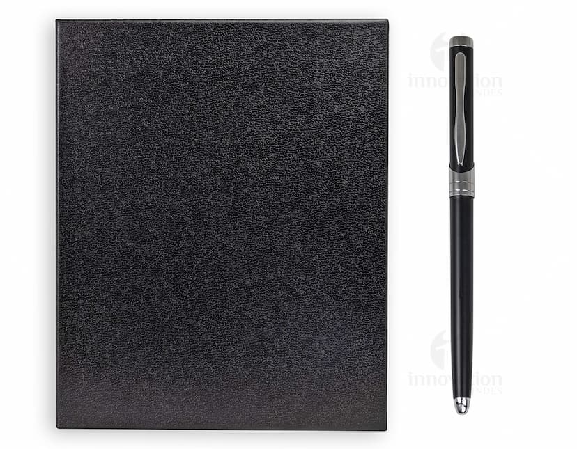 Kit executivo 2 peças composto por uma agenda preta de couro e uma caneta prateada.