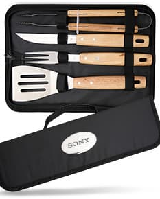 Kit churrasco contendo 4 peças de utensílios de aço inoxidável, incluindo espátula, garfo, faca e pegador. O conjunto vem em uma maleta de plástico preta, ideal para churrascos e outras atividades ao ar livre.