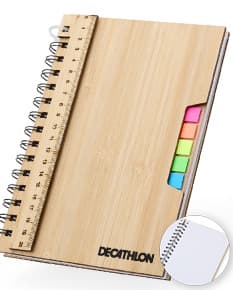 Caderno A5 Bambu em textura de bambu, aberto e com páginas em branco. Possui régua de medição, instrumento de medição, notebook, papel, anotações, espaço para escrever e design clean. Ideal para estudo, trabalho ou projetos.