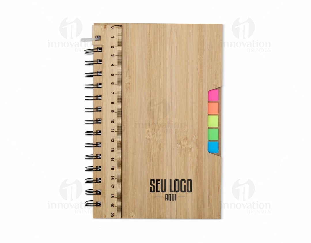 Caderno A5 Bambu em textura de bambu, aberto e com páginas em branco. Possui régua de medição, instrumento de medição, notebook, papel, anotações, espaço para escrever e design clean. Ideal para estudo, trabalho ou projetos.