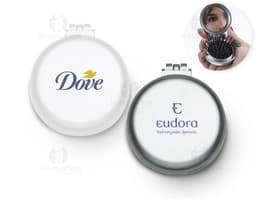 Espelho de bolsa com escova preta e vermelha, feito de vidro e metal, com um botão redondo para fechar. Possui um ícone de