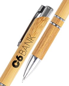 Caneta ecológica feita de bambu, em um ambiente de escritório com papel em branco e outros materiais de escrita.