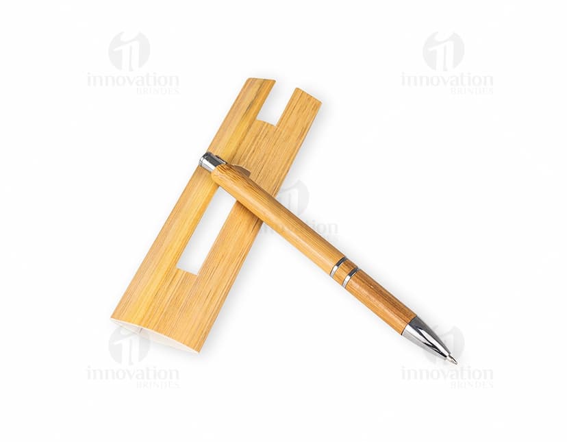 Caneta ecológica feita de bambu, em um ambiente de escritório com papel em branco e outros materiais de escrita.