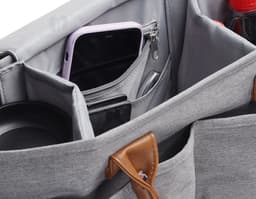 Bolsa multifuncional em couro preto e marrom com alça, zíper e fivela. Elegante e moderna, ideal para o dia a dia ou viagens.