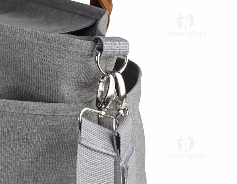 Bolsa multifuncional em couro preto e marrom com alça, zíper e fivela. Elegante e moderna, ideal para o dia a dia ou viagens.