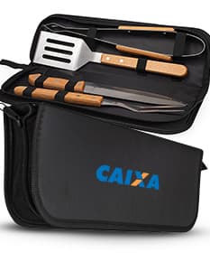 Kit churrasco 4 peças em caixa de couro preta contendo utensílios de metal e plástico, tais como faca, garfo, espátula e pegador. Ideal para uso em churrascos, com design moderno e prático.