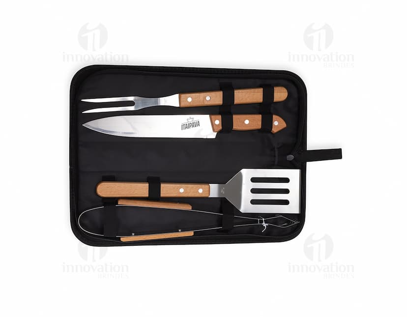Kit churrasco 4 peças em caixa de couro preta contendo utensílios de metal e plástico, tais como faca, garfo, espátula e pegador. Ideal para uso em churrascos, com design moderno e prático.
