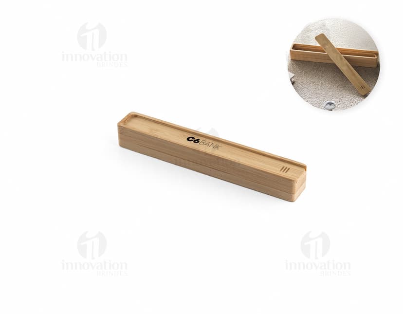 Estojo em bambu com fecho dourado, contendo lápis, caneta, régua e apontador.