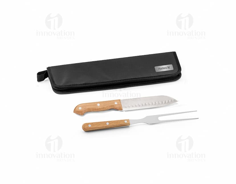 Kit churrasco com estojo contendo diversos utensílios em aço inoxidável, como faca, garfo, espeto, luva e pegador de carnes. Ideal para uso em churrascos e eventos ao ar livre.